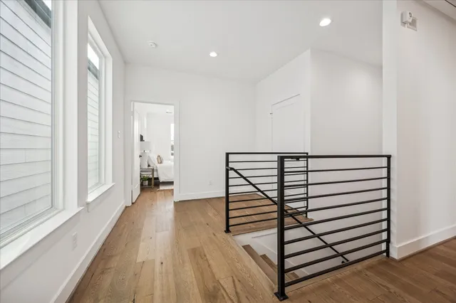 a view of a hallway with wooden floor and staircase
