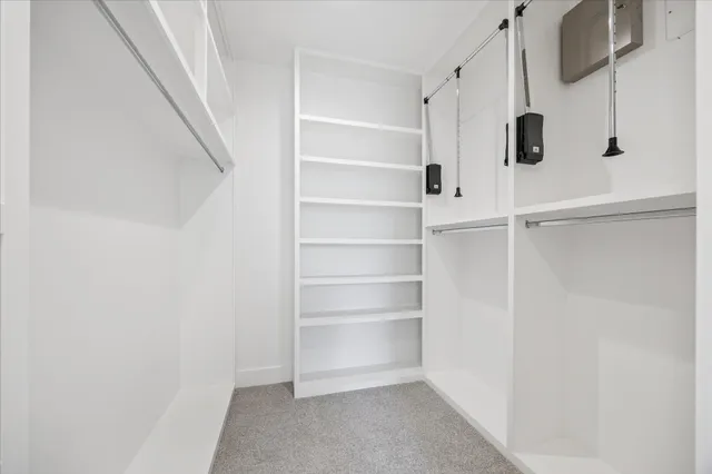 a view of walk in closet with empty racks