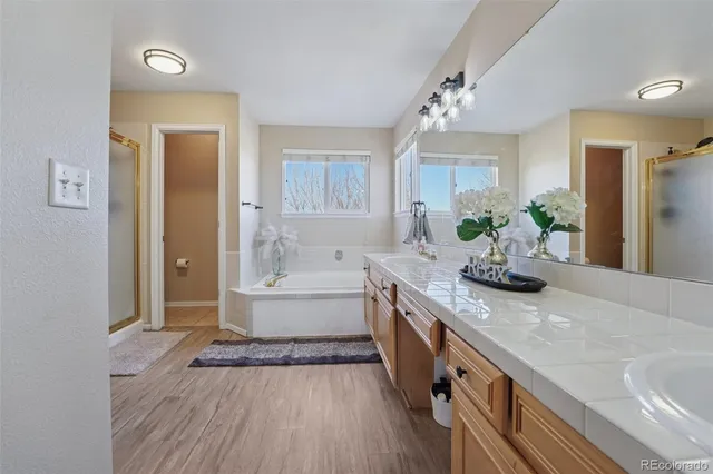 a spacious bathroom with a granite countertop tub a mirror and a sink