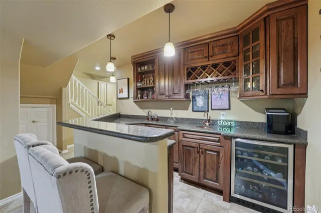 a kitchen with stainless steel appliances granite countertop a sink a stove and a wooden cabinets