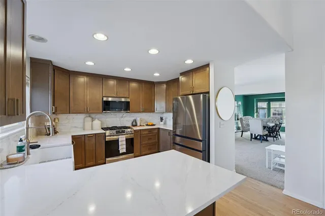 a kitchen with stainless steel appliances granite countertop a refrigerator a stove top oven a sink and dishwasher
