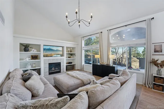 a living room with furniture fireplace and a large window