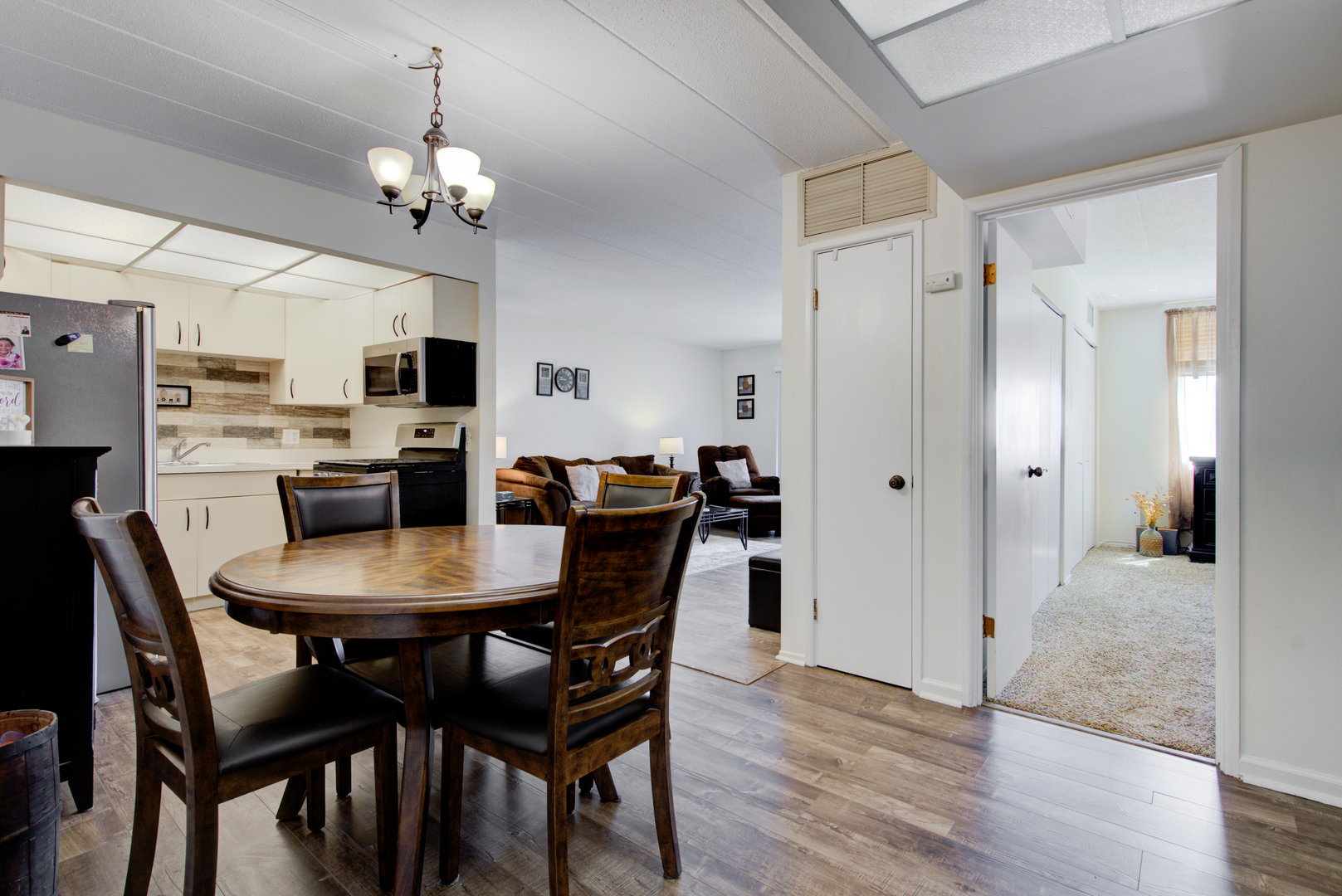 100 West Butterfield Road, Unit 512N Elmhurst, IL 60126 - Photo 3 of 16 a view of a dining room with furniture a chandelier and wooden floor