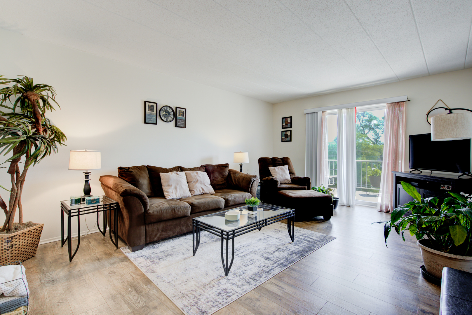 100 West Butterfield Road, Unit 512N Elmhurst, IL 60126 - Photo 6 of 16 a living room with furniture potted plant a flat screen tv and a large window