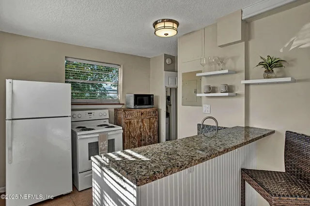 a kitchen with refrigerator and stove