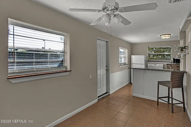 a view of kitchen with windows and ceiling fan