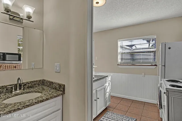 a bathroom with a granite countertop sink a mirror and a shower