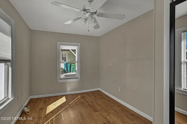 a view of empty room with window and ceiling fan