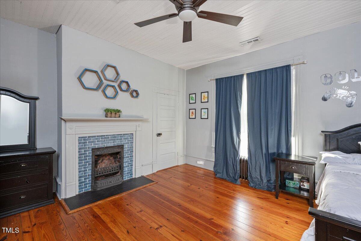 26 Oak Street Roxboro, NC 27573 - Photo 33 of 56 a bedroom with a bed and a fireplace