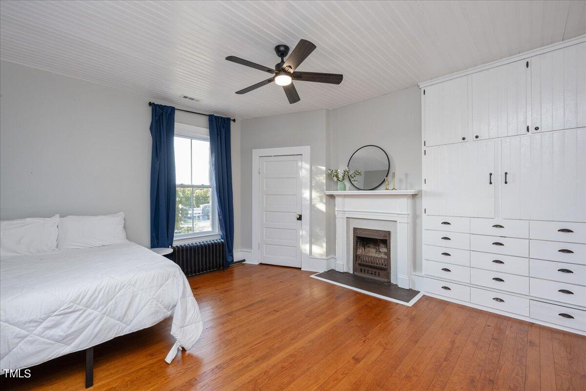 26 Oak Street Roxboro, NC 27573 - Photo 34 of 56 a bedroom with a bed and a fireplace