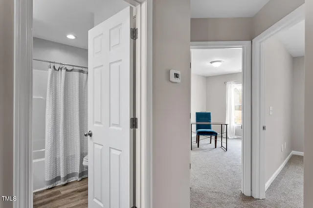 a view of a hallway with wooden floor and furniture