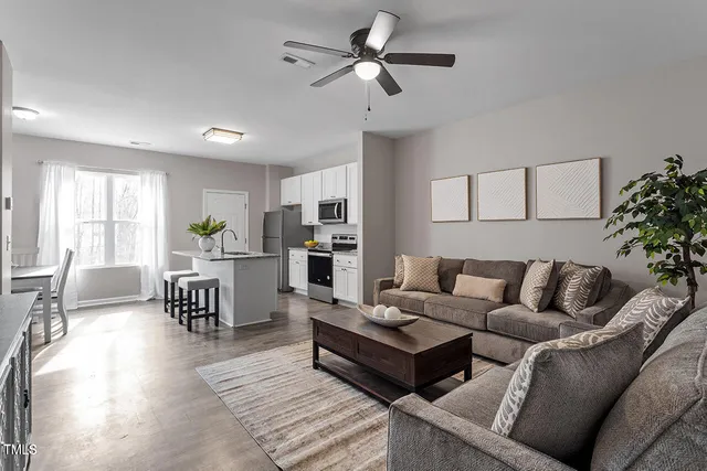 a living room with furniture and kitchen area