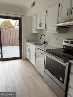 a kitchen with granite countertop white cabinets and white appliances