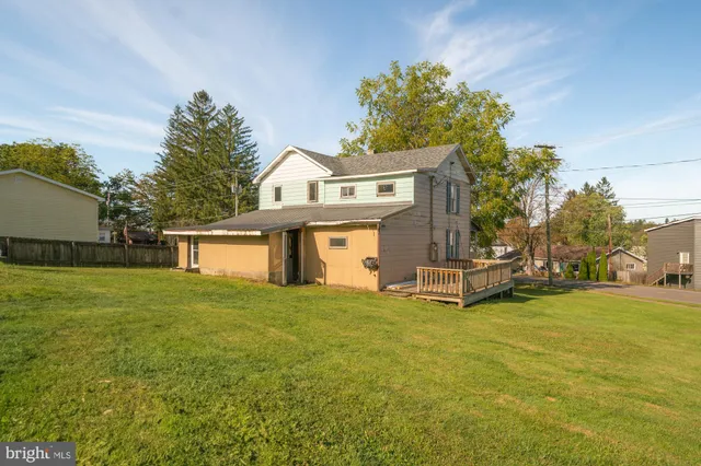 a front view of a house with a yard and trees