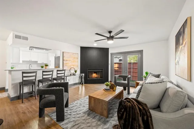 a living room with furniture and a flat screen tv with kitchen view