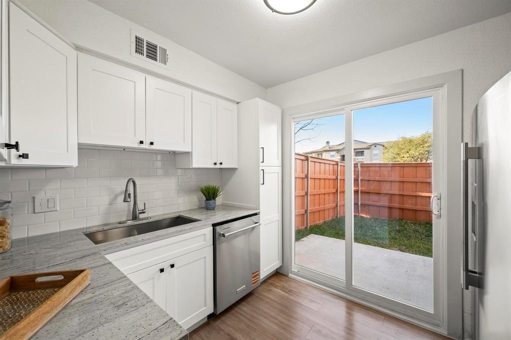 4247 Madera Road Irving, TX 75038 - Photo 12 of 28 a kitchen with granite countertop a sink and white cabinets