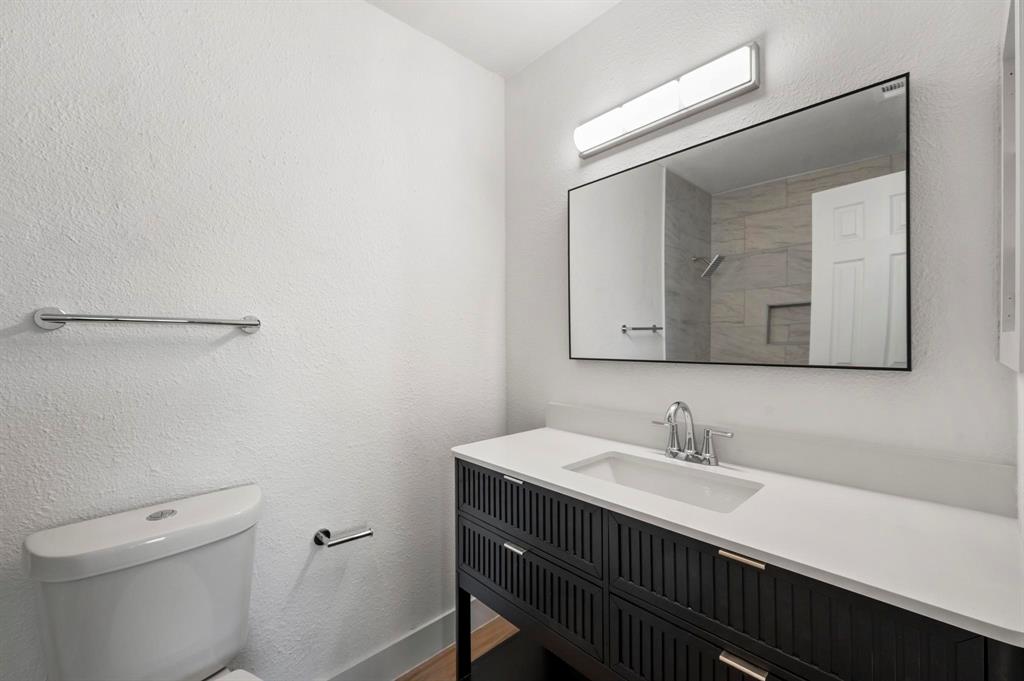 4247 Madera Road Irving, TX 75038 - Photo 16 of 28 a bathroom with a sink vanity and a toilet