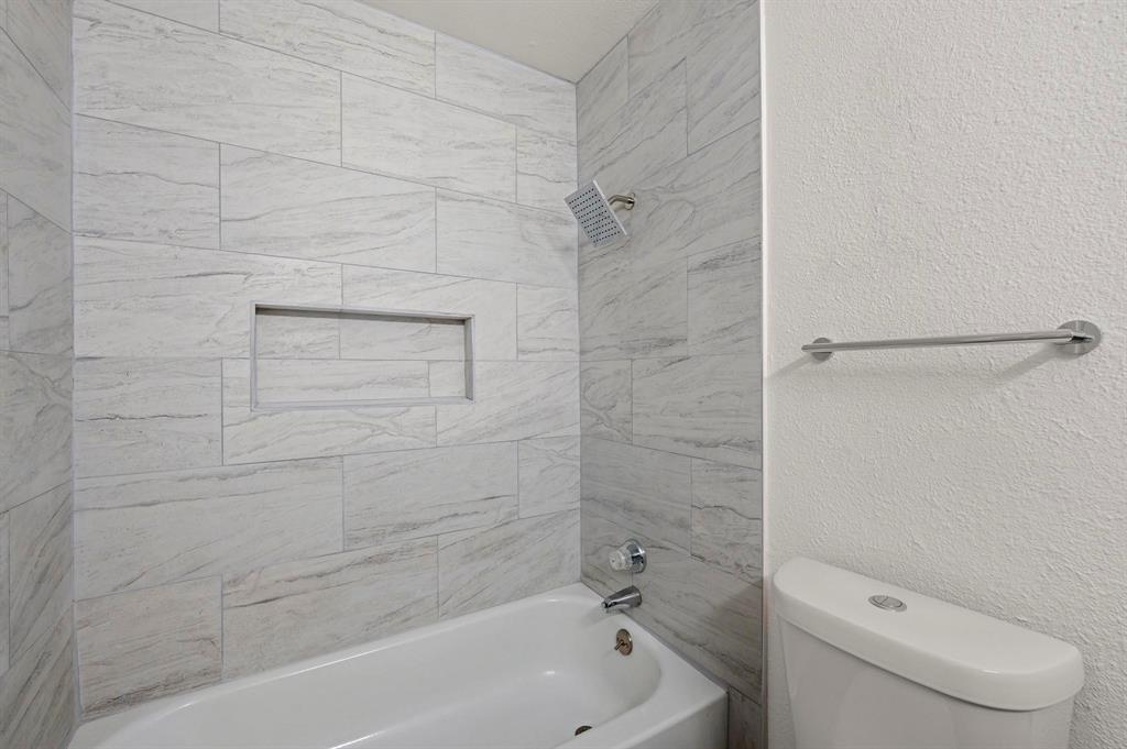 4247 Madera Road Irving, TX 75038 - Photo 17 of 28 a bathroom with a toilet and a tub