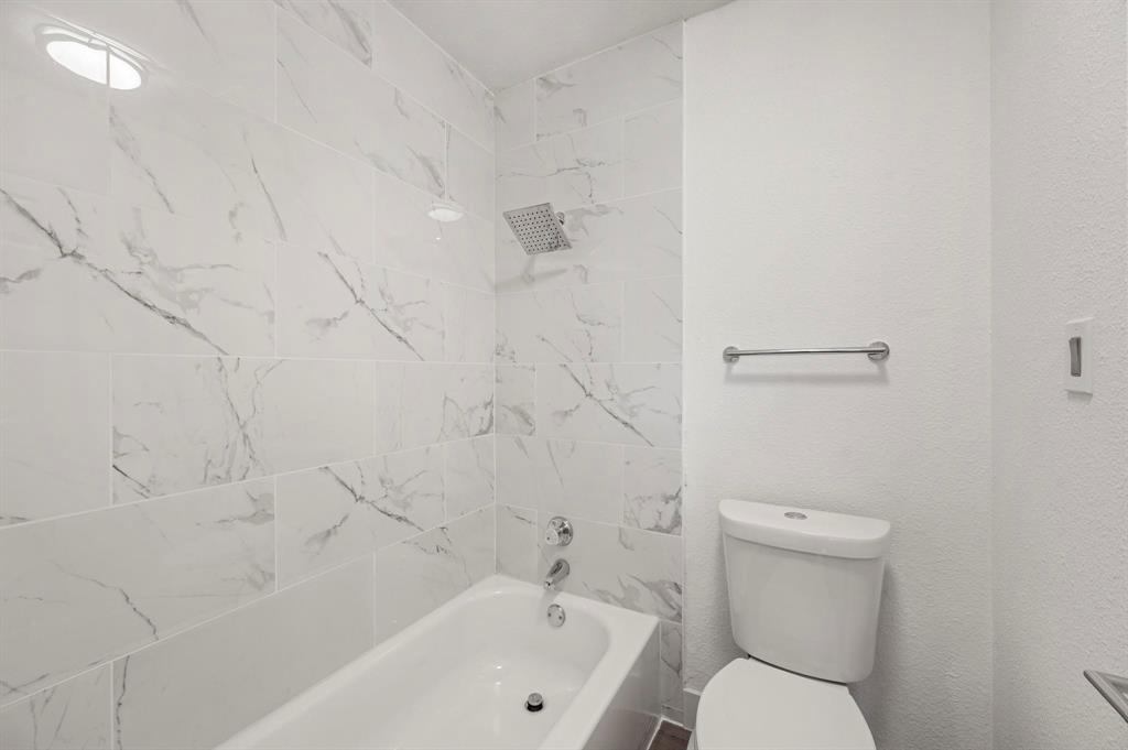4247 Madera Road Irving, TX 75038 - Photo 22 of 28 a bathroom with a toilet and a bathtub