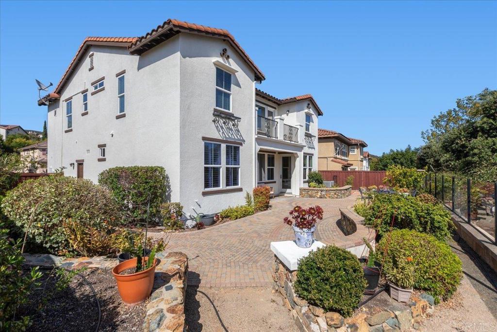 838 Luminara Way San Marcos, CA 92078 - Photo 50 of 54 a view of a white house with a yard and potted plants