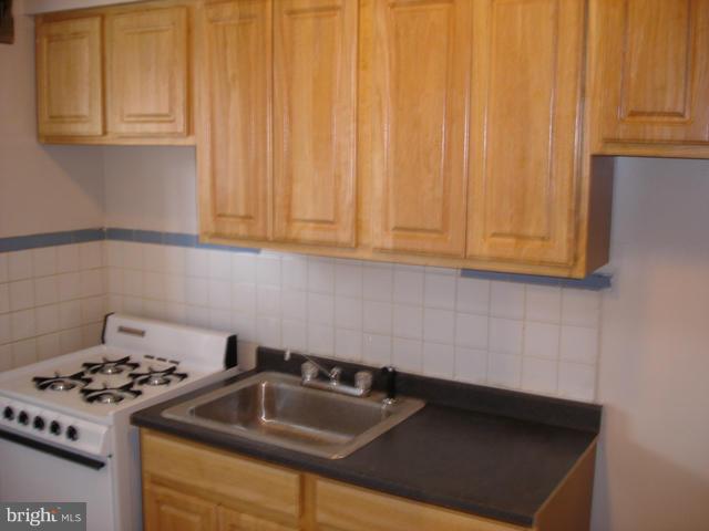 1061 Cameron Road Baltimore, MD 21212 - Photo 2 of 8 a kitchen with granite countertop a sink stove and cabinets