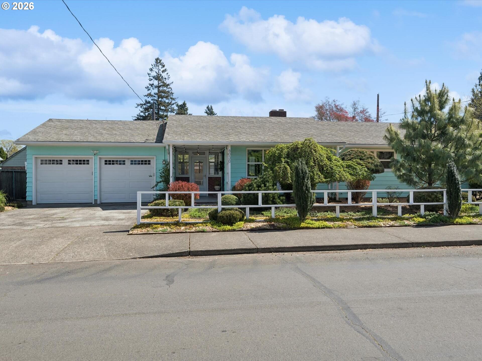 6030 Southeast 80th Avenue Portland, OR 97206 - Photo 2 of 42 a view of a white house with a yard and plants