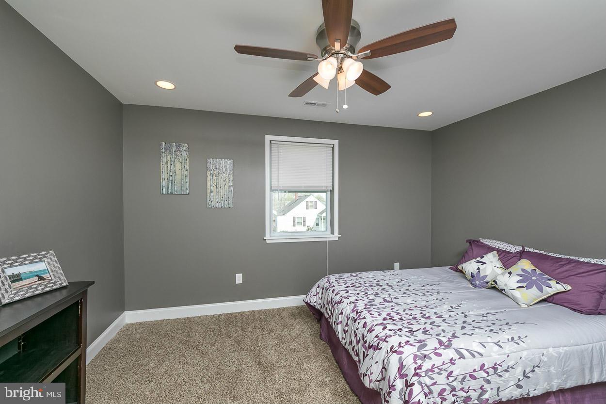 8221 Longpoint Road Baltimore, MD 21222 - Photo 14 of 24 a bedroom with a large bed and a chandelier