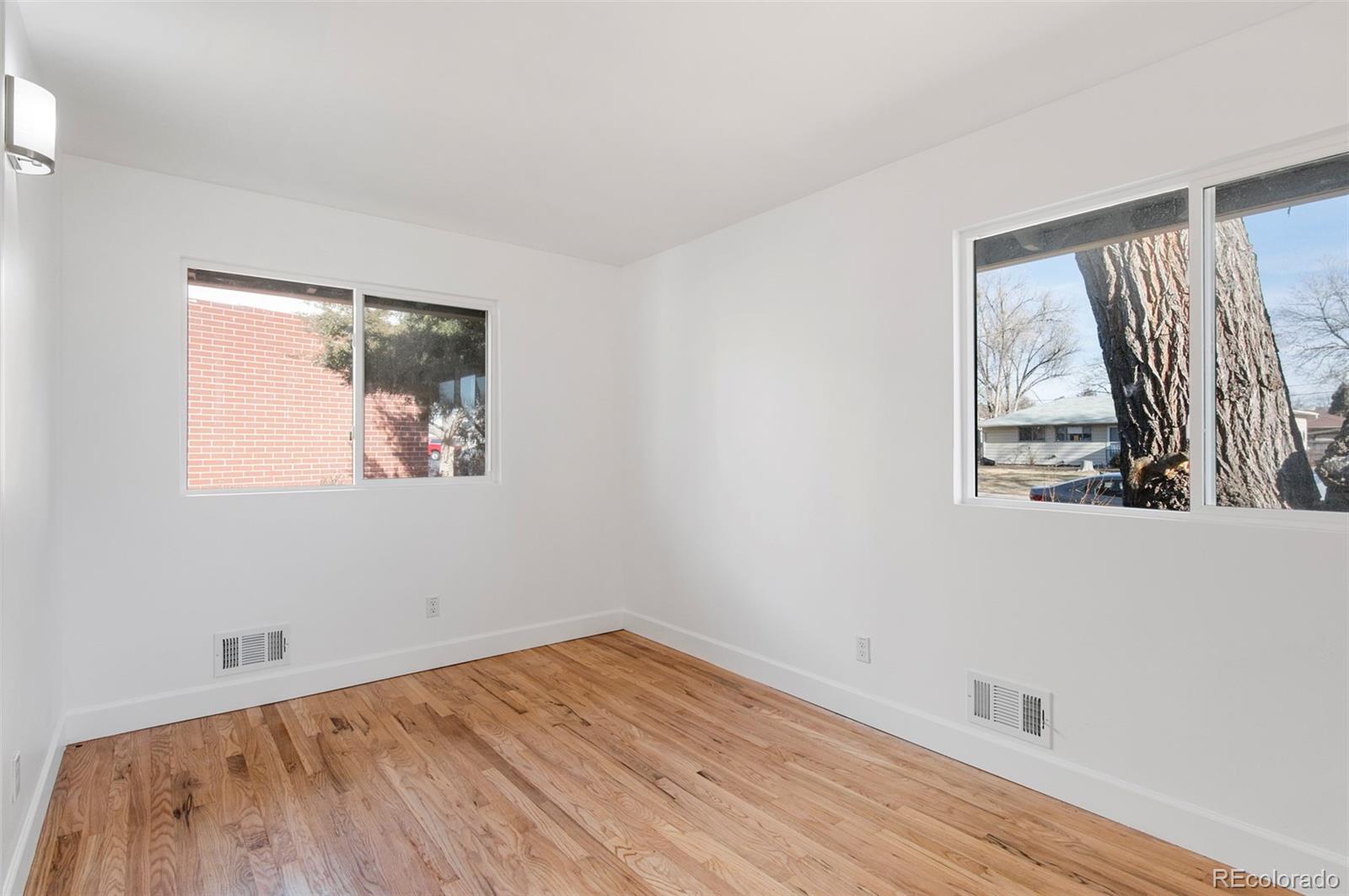 7483 Knox Court Westminster, CO 80030 - Photo 14 of 35 an empty room with wooden floor and windows
