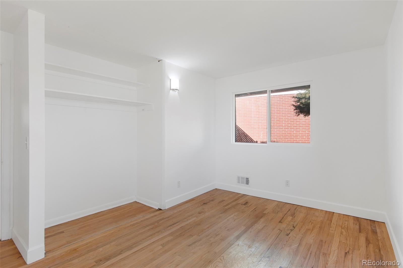 7483 Knox Court Westminster, CO 80030 - Photo 15 of 35 an empty room with wooden floor and windows