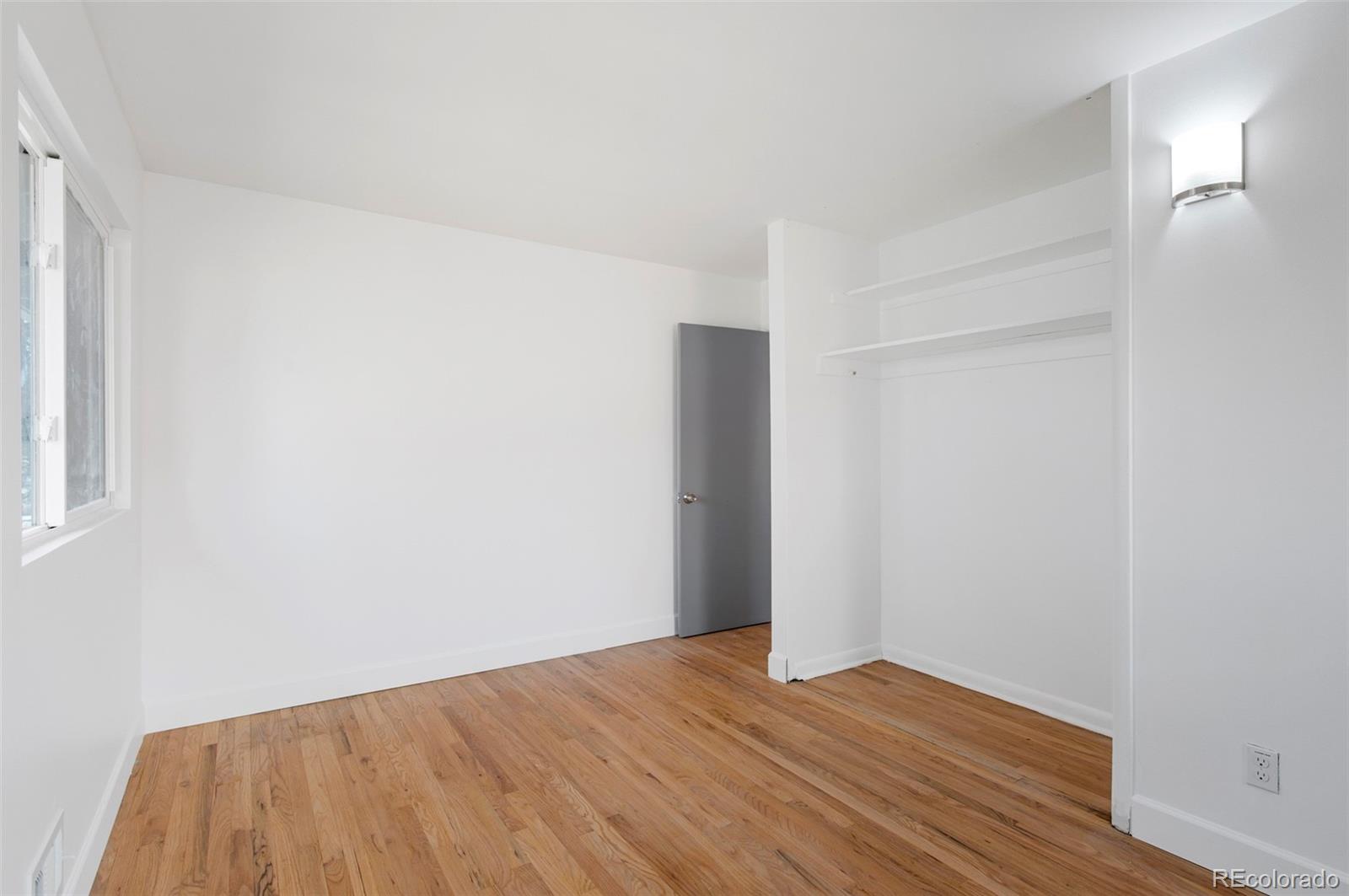 7483 Knox Court Westminster, CO 80030 - Photo 16 of 35 a view of an empty room with wooden floor