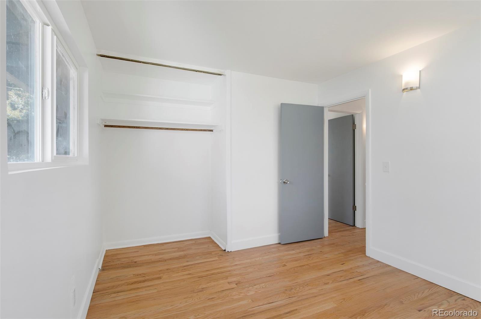 7483 Knox Court Westminster, CO 80030 - Photo 18 of 35 a view of an empty room with wooden floor and a window