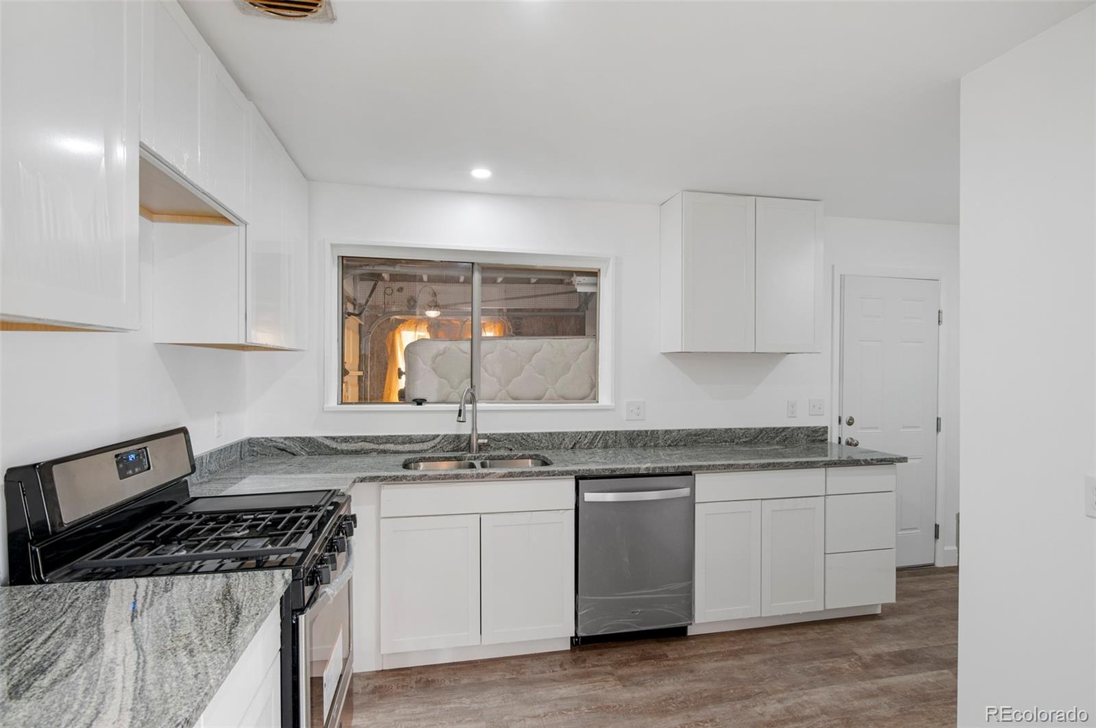 7483 Knox Court Westminster, CO 80030 - Photo 20 of 35 a kitchen with a sink stove and cabinets