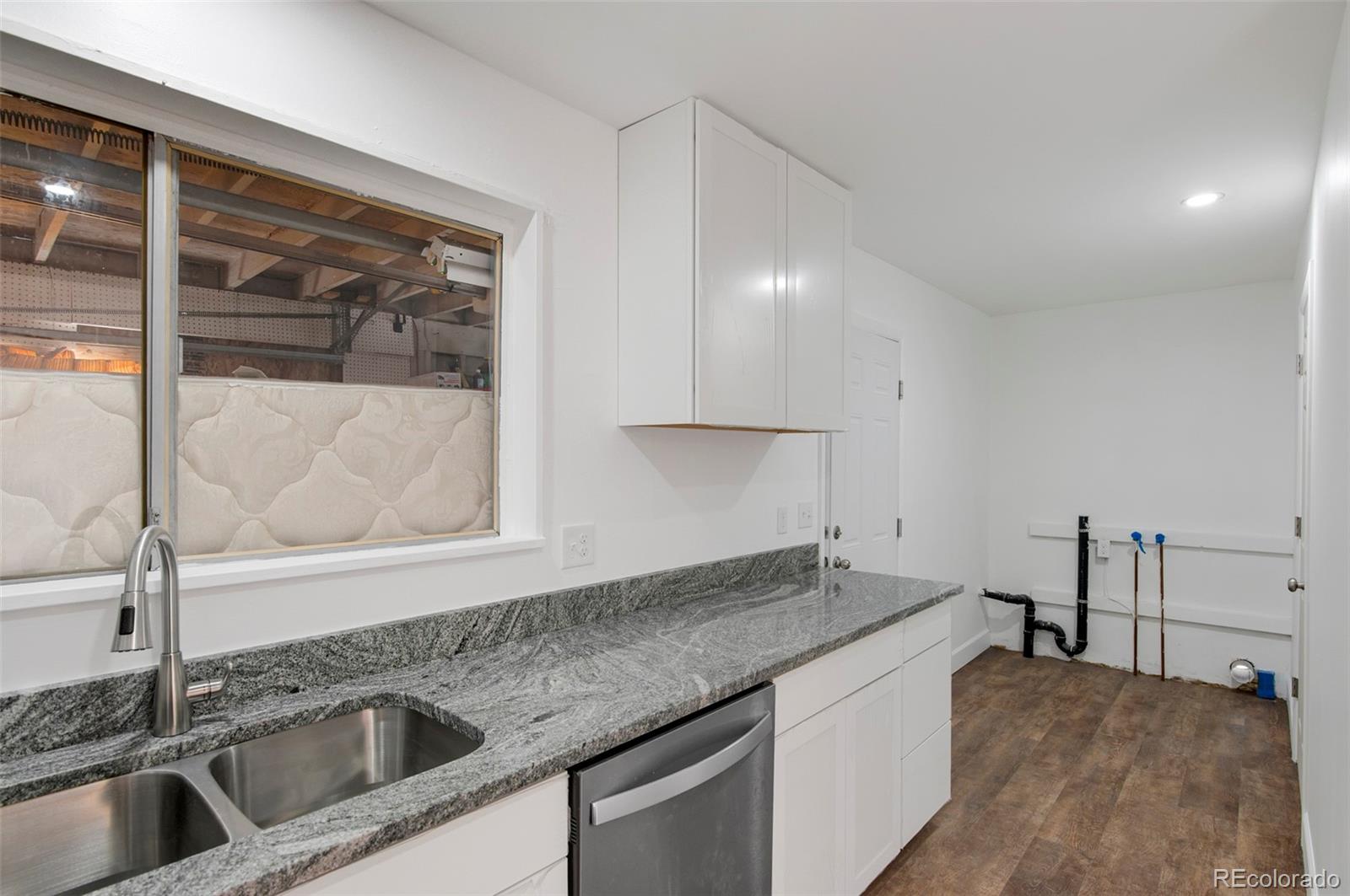 7483 Knox Court Westminster, CO 80030 - Photo 25 of 35 a kitchen with a sink and a refrigerator