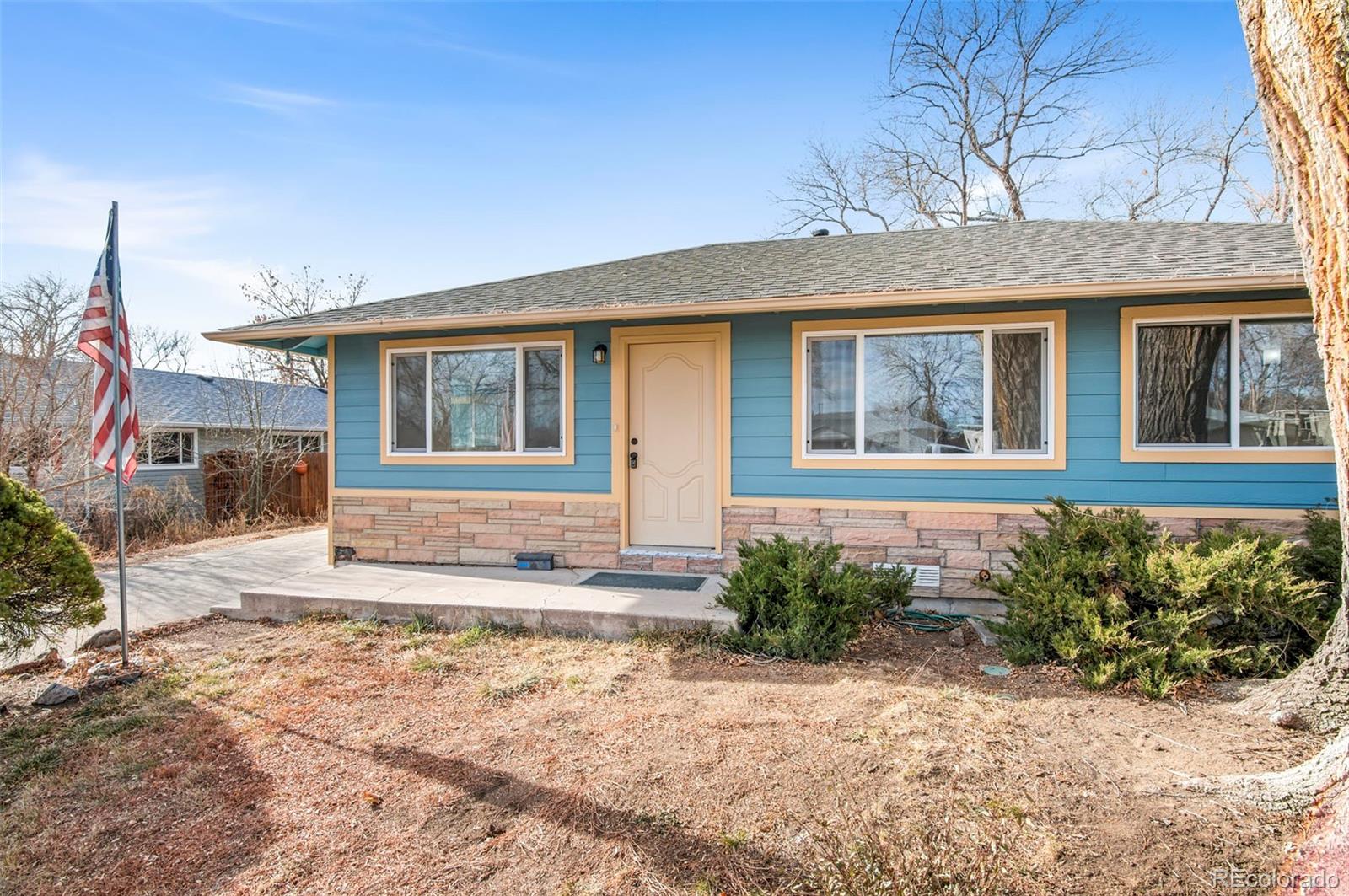 7483 Knox Court Westminster, CO 80030 - Photo 5 of 35 a front view of a house with garden