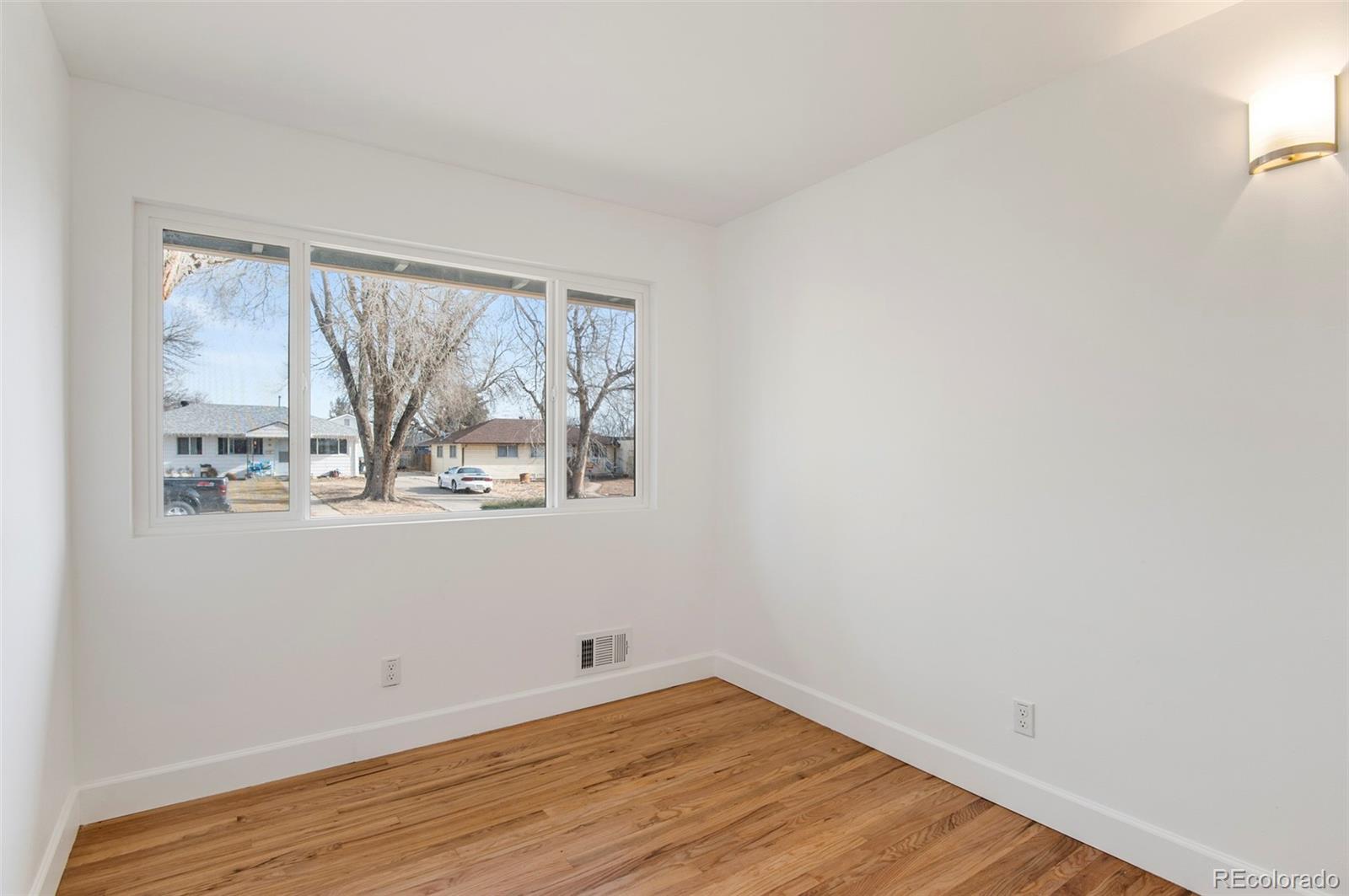 7483 Knox Court Westminster, CO 80030 - Photo 6 of 35 a view of wooden floor and windows in a room