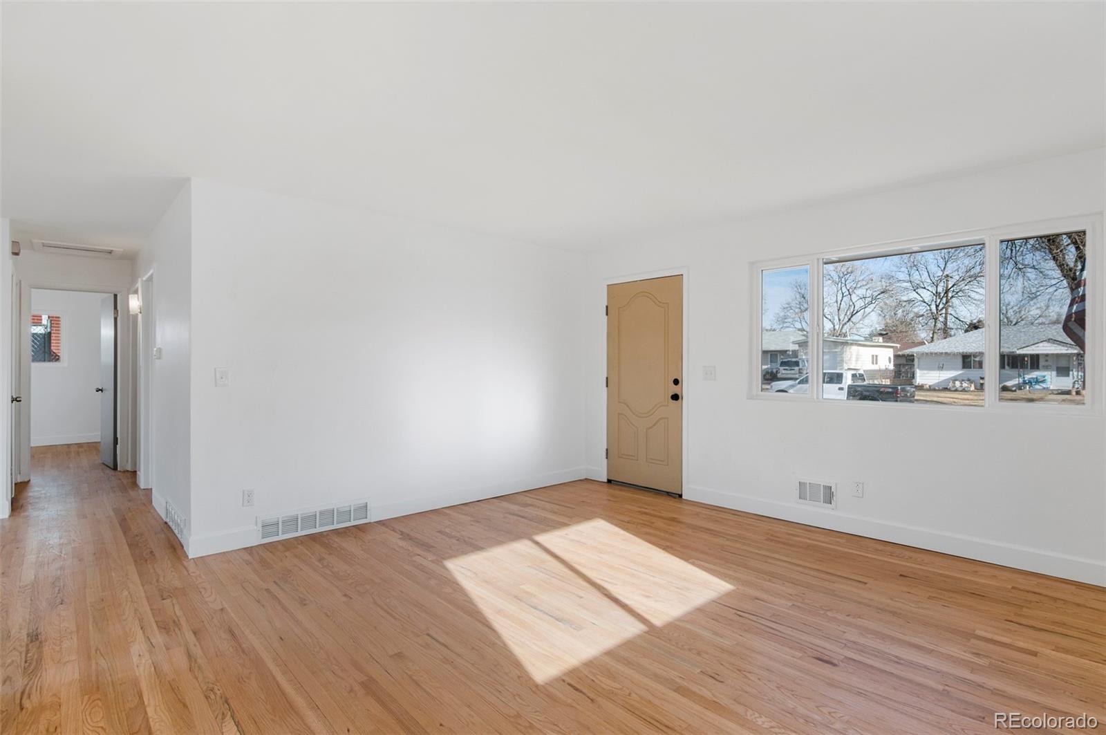 7483 Knox Court Westminster, CO 80030 - Photo 9 of 35 a view of a room with wooden floor and window