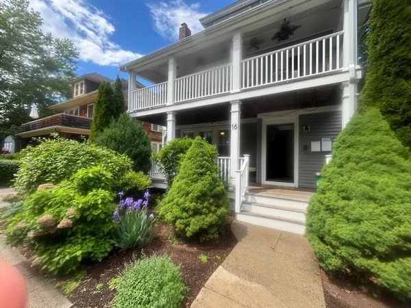 a front view of a house with plants