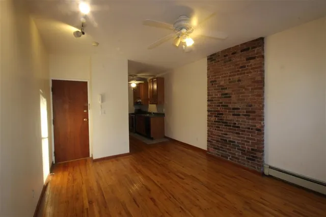 a view of livingroom with hardwood floor and kitchen space