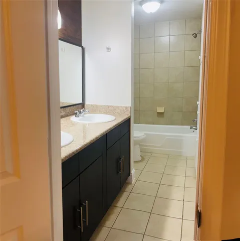 a bathroom with a granite countertop sink a toilet and shower