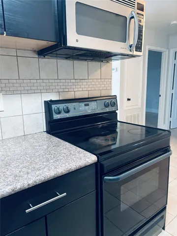 a kitchen with granite countertop a stove and a microwave