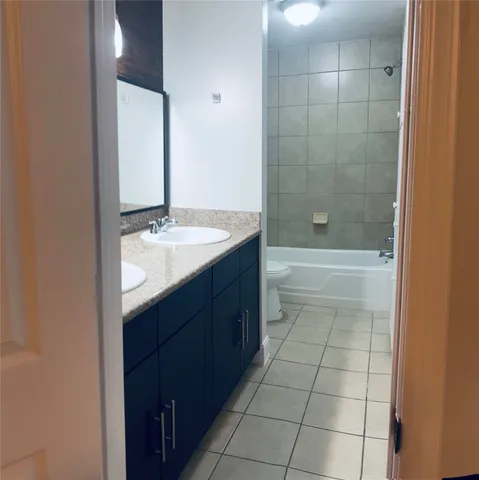 a bathroom with a granite countertop sink a toilet and shower