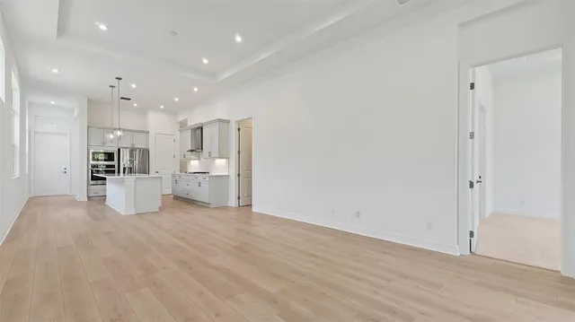 a kitchen with a sink stainless steel appliances cabinets and a wooden floor