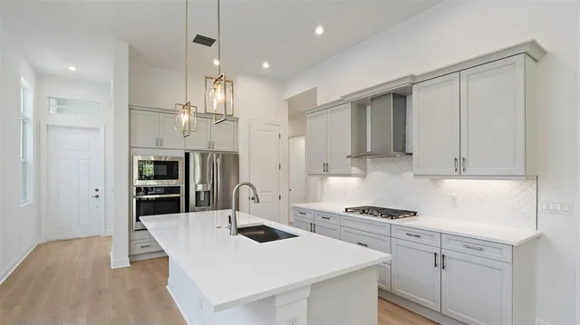 a kitchen with stainless steel appliances a refrigerator stove and sink