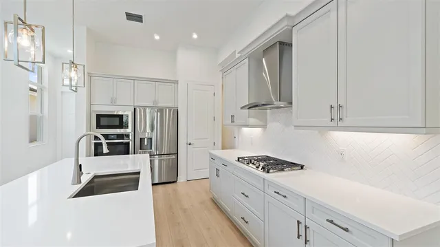 a kitchen with stainless steel appliances a sink and a refrigerator