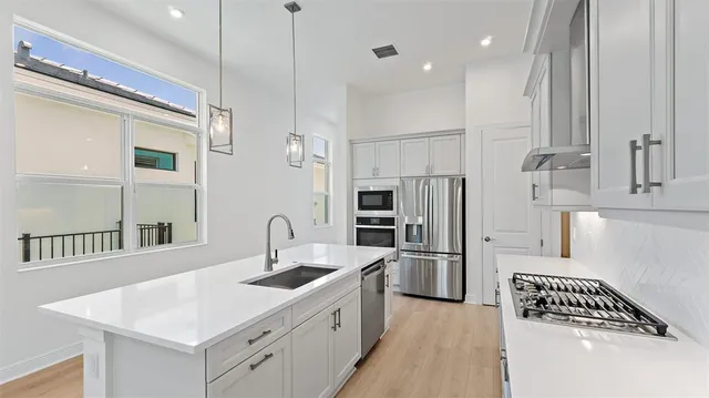 a kitchen with a sink appliances and a window