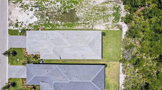 an aerial view of residential houses with outdoor space and swimming pool
