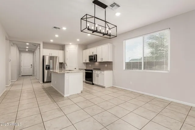 a kitchen with stainless steel appliances kitchen island granite countertop a refrigerator and a stove top oven