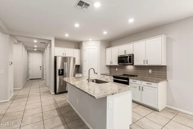 a kitchen with stainless steel appliances granite countertop a refrigerator and a stove top oven