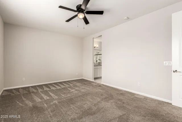 an empty room with closet and windows