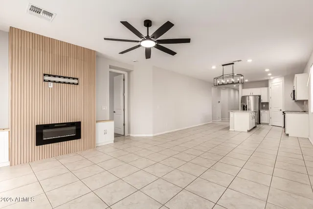 a view of a livingroom with a chandelier fan and windows
